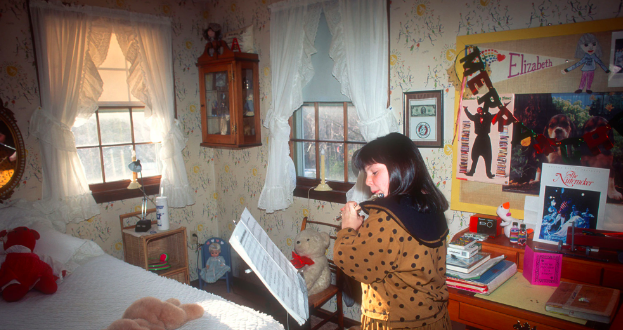 Elizabeth in her childhood bedroom practicing flute.
